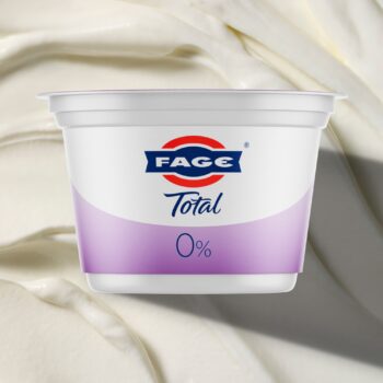 A white container of Fage Total 0% Plain Greek Yogurt. The packaging features the blue Fage logo and a large blue number '0' indicating the fat percentage.